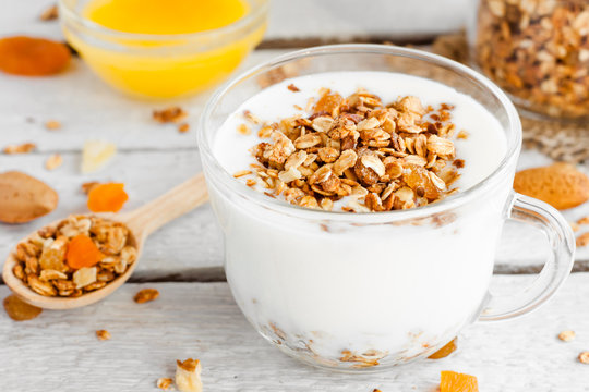 yogurt with homemade granola, nuts and dried fruits in a glass cup