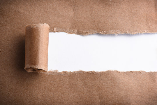 Brown paper torn to reveal white panel