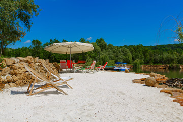 deck chairs on white sand near the water