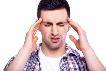 Fototapeta premium Feeling stressed. Frustrated handsome young man touching his head and keeping eyes closed over white isolated background