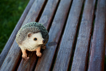 naturalistic statuette of a hedgehog standing on garden bench