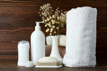 personal hygiene items with decorative sprigs on a brown wooden background