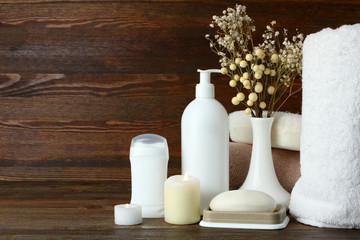 personal hygiene items with decorative sprigs on a brown wooden background