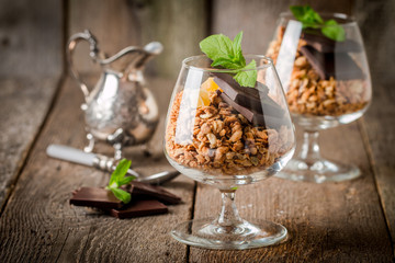 granola in glass with pieces of dark chocolate 