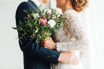 bride and groom together holding wedding bouquet