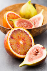 Mixed citrus fruit figs, limes on a gray background.
