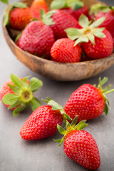 Strawberry in a bowl on the gray background.