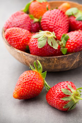 Strawberry in a bowl on the gray background.