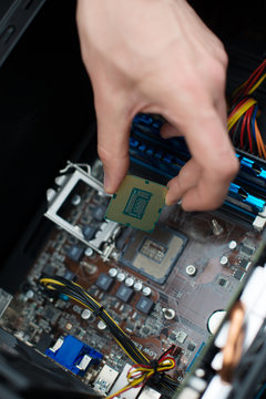 Computer technician installing CPU into motherboard.