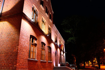 Ceglany budynek niezwykle oświetlony w nocy - obrazy, fototapety, plakaty