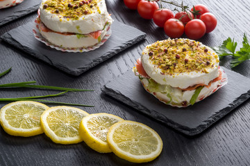 Tortini di formaggio cremoso  e salmone su piattini di ardesia ambientati