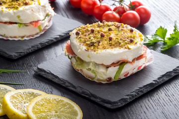 Tortino di formaggio cremoso  e salmone affumicato su piatto di ardesia ambientato 