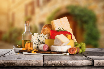 Delicious cheeses on old wooden table.