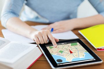 close up of woman with navigator map on tablet pc