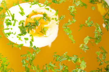 Obraz na płótnie Canvas Chicken bouillon with egg and minced parsley.