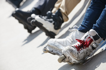 Aggressive inline rollerblader sitting on ramp in skatepark