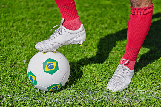 Kick off Brazil. Soccer player, foot on ball with Brazilian flags