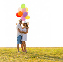 smiling couple with air balloons outdoors