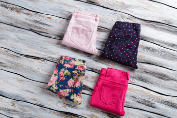 Blue and bright pink pants. Woman's folded casual trousers. Top quality merchandise on showcase. Clothing from fashion catalog.