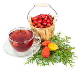 Wooden bucket with berries  wild rose and cup  tea isolated.