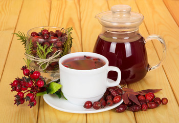 Hips,  pitcher with  drink and  cup tea on light wood.