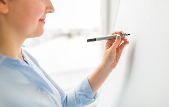 close up of woman writing something on white board