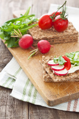 Crispbread with tomatoes, radish, cucumber and arugula