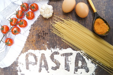 Products for cooking pasta. Tomato, egg, spaghetti, garlic, parsley, spices.