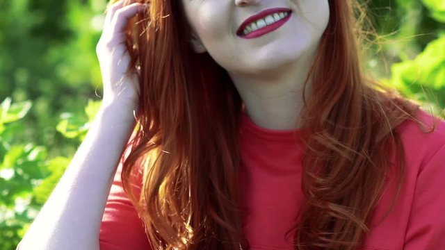 Portrait of happy girl smiling in the green wheat field. Slowly