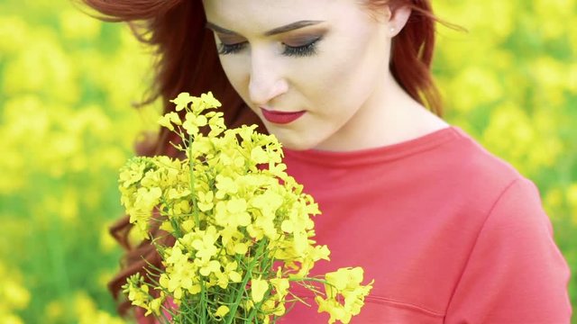 Close up of pretty girl smelling rape bouquet. Slow motion