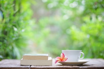 Notebook with and cup with flower on wooden table