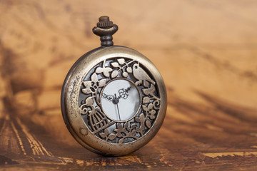 Pocket watch on old map background, vintage style light and tone