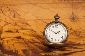 Pocket watch on old map background, vintage style light and tone