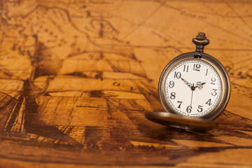 Pocket watch on old map background, vintage style light and tone