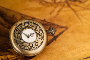 Fototapeta na wymiar Pocket watch on old map background, vintage style light and tone