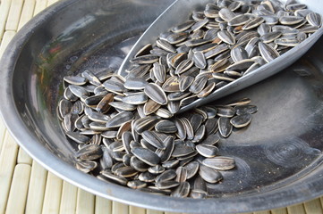 sunflower seed in iron scoop on circle stainless tray