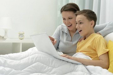 Mother and son using laptop