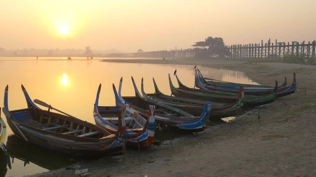 Wooden boat in Ubein Bridge at sunrise, Mandalay, Myanmar 
