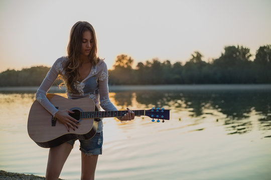 Girl playing guitar on the beach