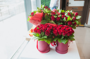 Beautiful bouquets of red roses in gift box, on white window sill