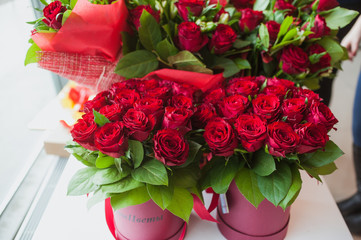 Beautiful bouquets of red roses in gift box, on white window sill