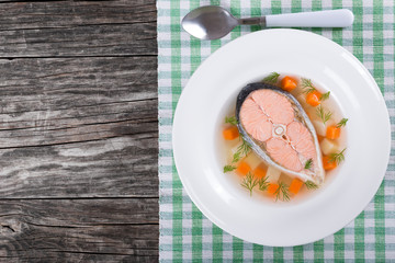salmon soup with vegetables and dil, top view