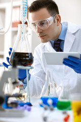 Fototapeta premium scientist analysis chemical experiment with tablet.