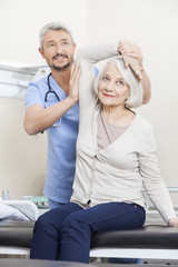 Obraz premium Physiotherapist Helping Senior Patient With Arm Exercise