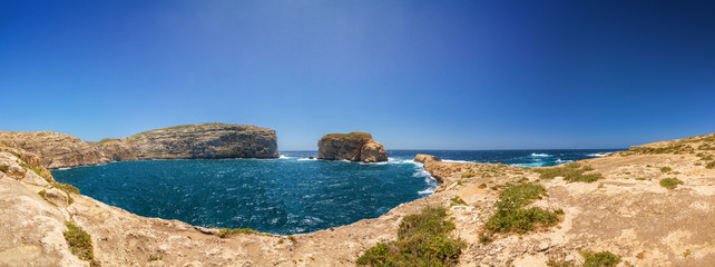Fototapeta na wymiar Sunny wide panoramic view of rocky Dweira bay in Gozo, Malta.