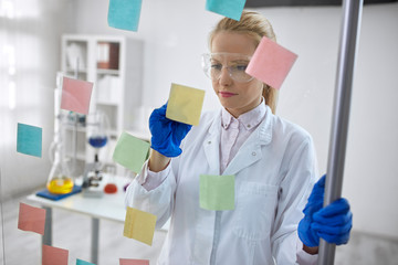 Woman scientist in laboratory write chemical formula.