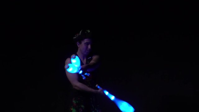 Juggler showing tricks with light balls in the whole dark.Close up.Slow motion