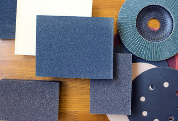 Abrasive materials - sheets of sandpaper and disks close-up - obrazy, fototapety, plakaty