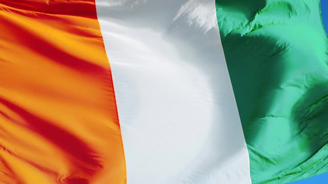 Cote Ivoire flag waving in slow motion against clean blue sky, seamlessly looped, close up, isolated on alpha channel with black and white luminance matte, perfect for film, news, digital composition