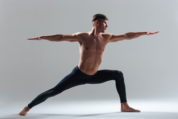 Full length portrait of a man doing yoga exercises